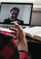 person in red and black plaid long sleeve shirt using black laptop computer